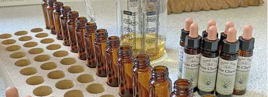 Hand pouring White Chestnut Remedy - bottles, pouring jug, completed remedies